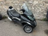 a scooter that is parked in front of a stone wall