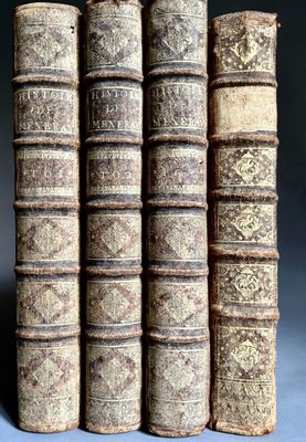 quatre vieux livres empilés les uns sur les autres sur une table
