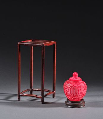 deux vases rouges et un petit vase rouge posés sur une table