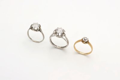 trois bagues en or et en argent serties de diamants sur fond blanc