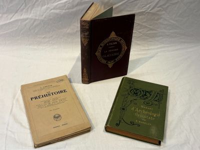 three books that are sitting on a white surface
