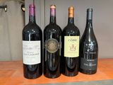 quatre bouteilles de vin sont alignées sur une table