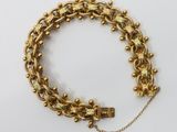 an image of a gold bracelet with a lock on a chain