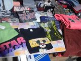 une pile de t-shirts et d'autres objets posés sur une table