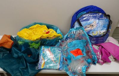 de nombreux sacs de vêtements posés sur une table dans la pièce