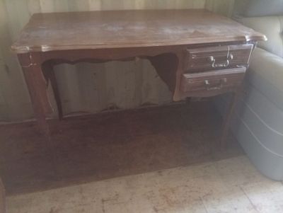 un bureau en bois avec des tiroirs et une chaise dans un coin