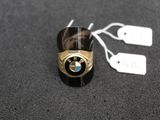 une bague ornée d'un emblème BMW, posée sur une table