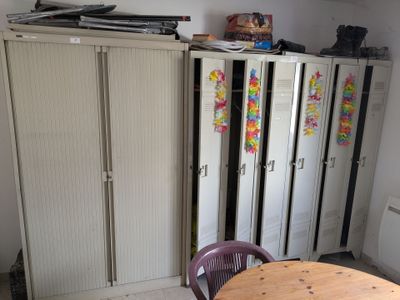 cabinets and a table in a room with a lot of clutter on top of them