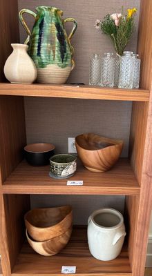 une étagère en bois sur laquelle sont posés des bols et des vases