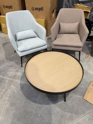 trois chaises et une table dans un entrepôt, avec des cartons en arrière-plan