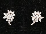 deux paires de boucles d'oreilles en diamant posées sur un fond de velours noir