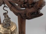 a bell with a dragon on it sitting next to a glass of wine