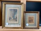 two framed paintings of a man and a woman on a shelf