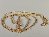 a close up of a gold chain on a white surface