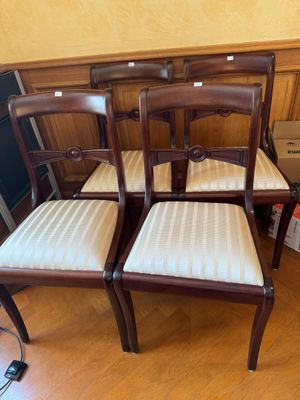 quatre chaises en bois avec des assises rembourrées dans une pièce