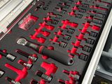 un jeu d'outils rangé dans une boîte à outils posée sur une table