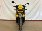 a yellow and black motorcycle parked in front of a white backdrop