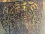 a gold plate with a design on it in a glass case