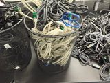 a lot of wires and cords in a bucket on a table