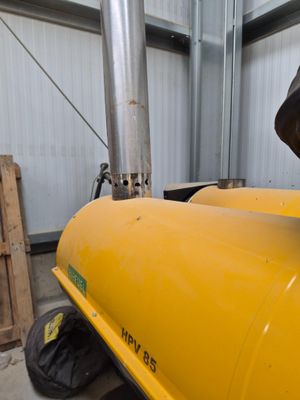 a man standing next to a yellow tank in a building