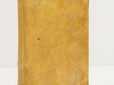 un vieux livre jaune posé sur une table blanche