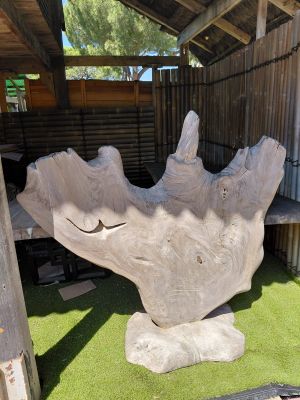 a large stone sculpture of a hand on a green lawn