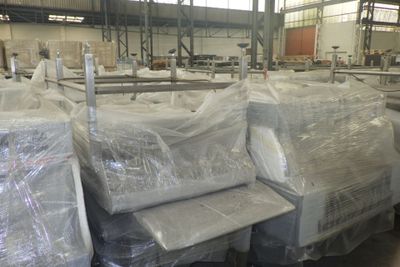 de nombreux meubles emballés dans du plastique dans un entrepôt