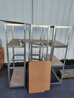 trois rayonnages métalliques sont empilés les uns sur les autres devant un bâtiment