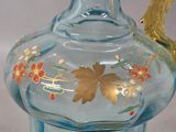 a blue glass vase with a gold leaf decoration on it
