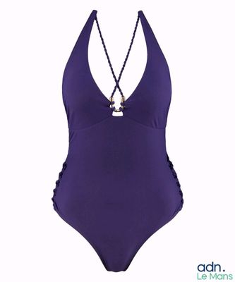 une femme en maillot de bain violet, avec une chaîne autour du cou