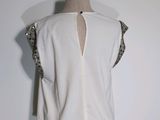 the back of a woman ' s white top with sequins on it
