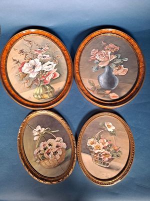 four framed pictures of flowers in a vase on a blue background