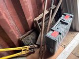 un tas d'outils posé par terre près d'un mur rouge