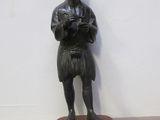 une statue représentant un homme debout sur un rocher