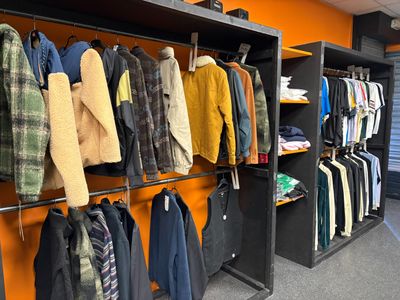 de nombreuses vestes suspendues à un portant dans un magasin