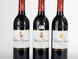 trois bouteilles de vin rouge posées côte à côte sur une table