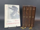 three books on a table next to a book case with a hat on it