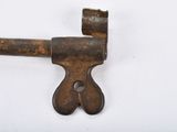an old rusty key on a white surface with a hole in the middle