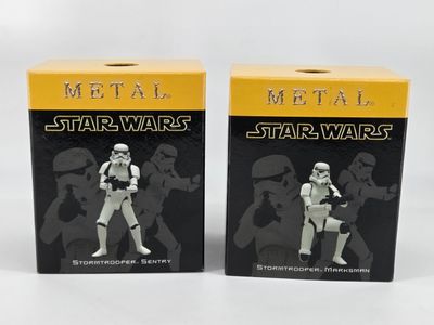 deux figurines de Star Wars sont posées devant une boîte