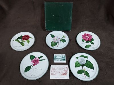 six sous-verres ornés de fleurs, posés sur une surface marron