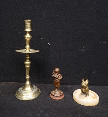 trois bougeoirs en laiton et une figurine sur fond noir