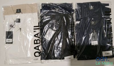 trois paires de t-shirts noirs et blancs posés sur une table