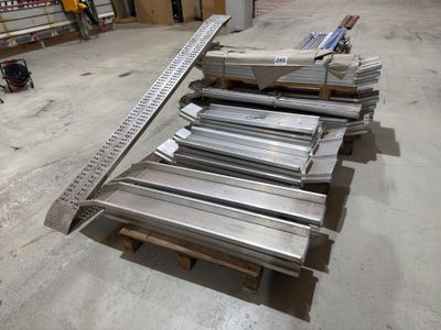 several pieces of metal are stacked on top of pallets in a warehouse