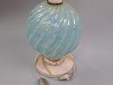 a blue glass lamp that is on a white base