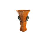 un vase en bois avec une anse verte sur fond blanc