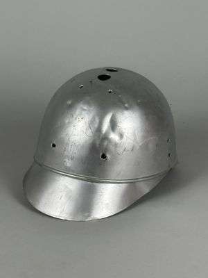 un vieux casque en argent troué, posé sur une table