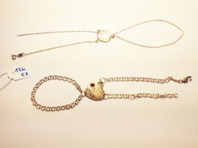 two pieces of jewelry that are laying on a table