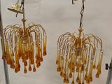 pair of yellow glass chandeliers hanging from a metal rack