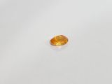 a yellow sapphire stone on a white surface
