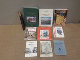 several books are sitting on a table in front of a wall